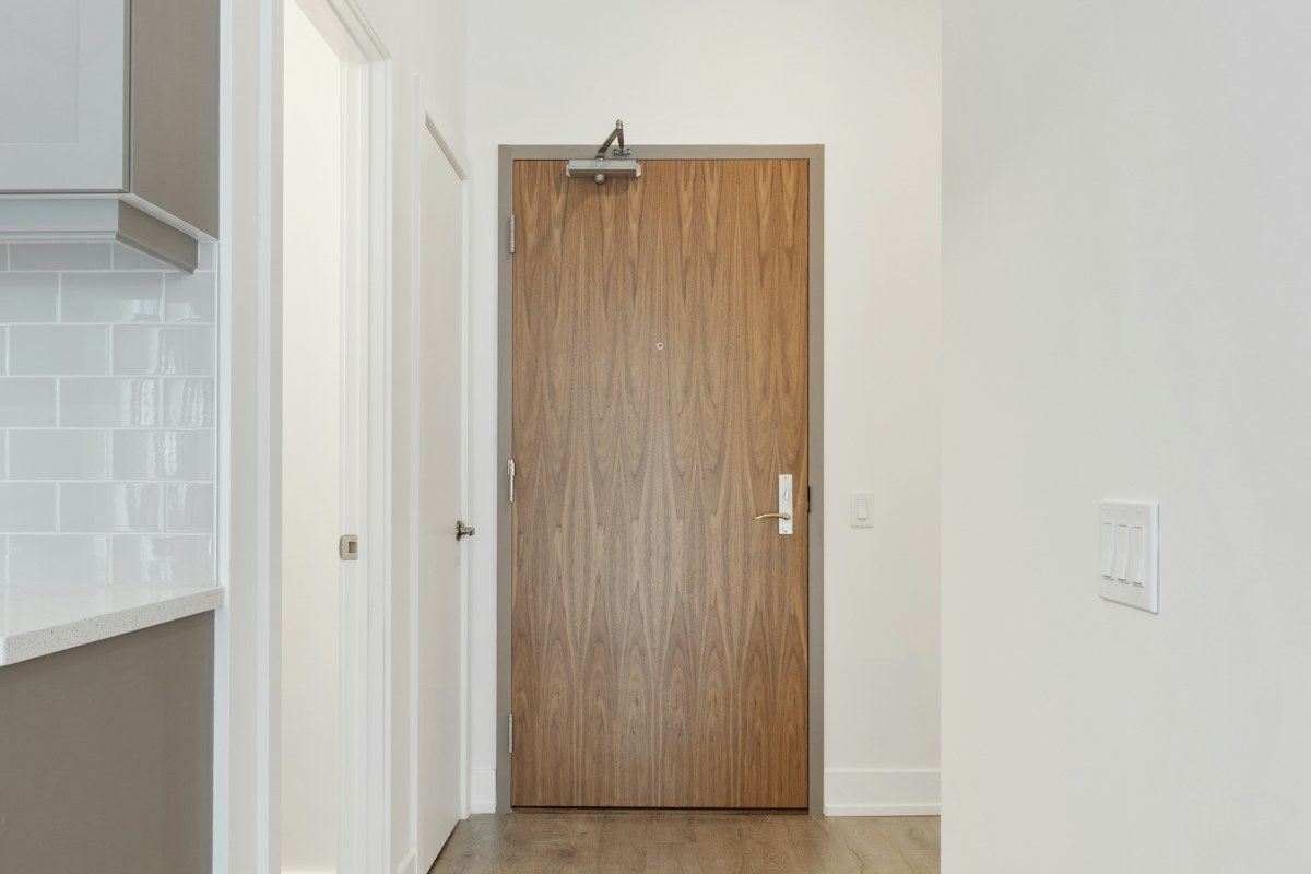 brown wooden door near white wall