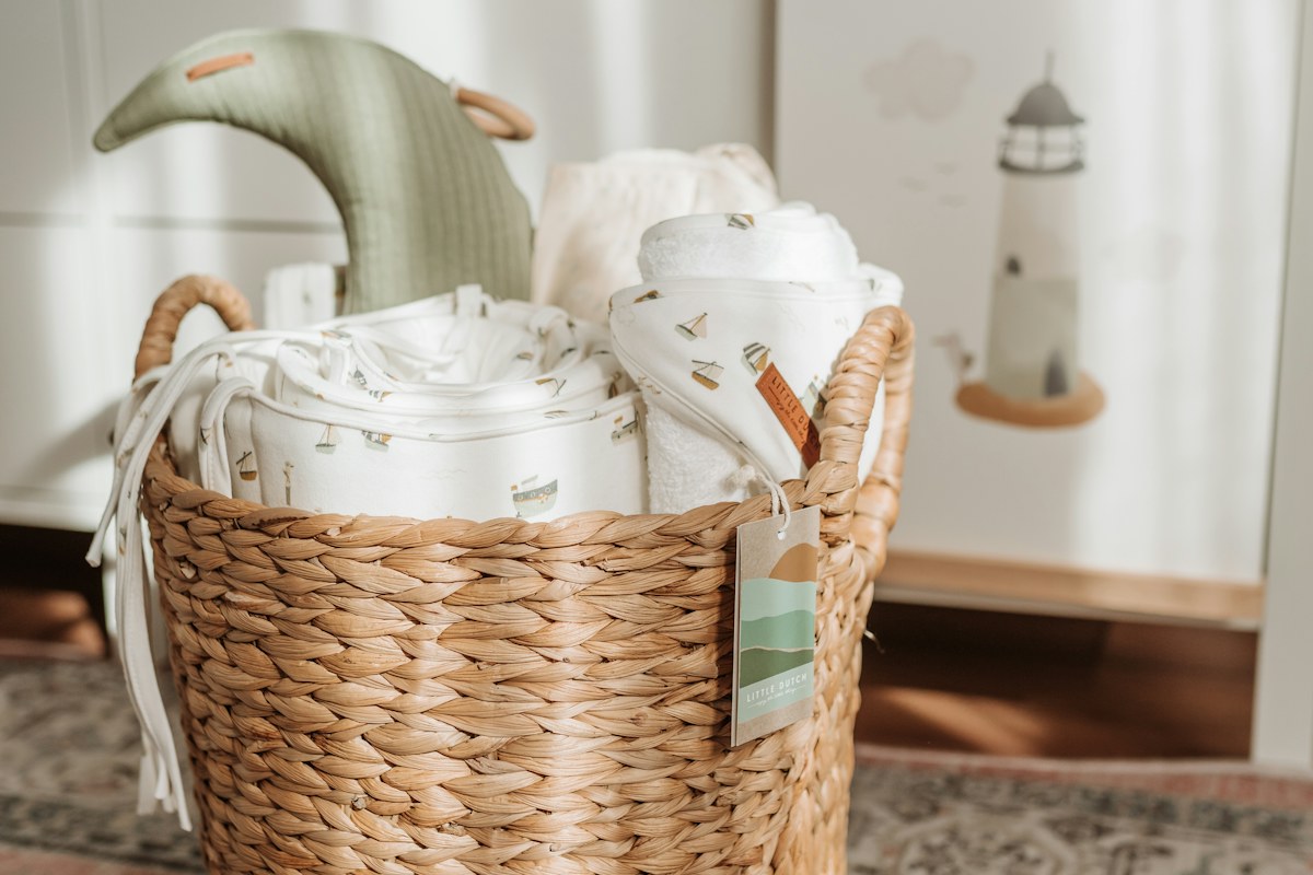 a wicker basket filled with blankets on top of a rug